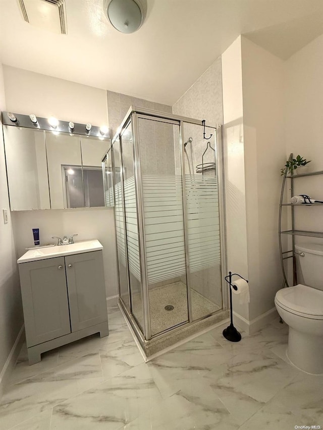 bathroom featuring vanity, toilet, and a shower with door