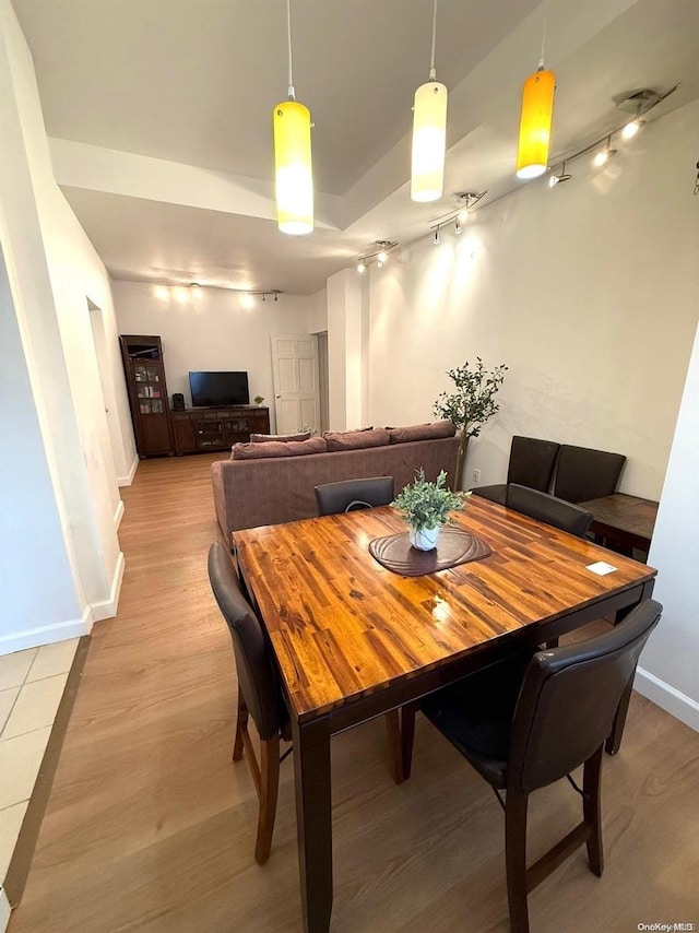 dining space featuring rail lighting and light wood-type flooring