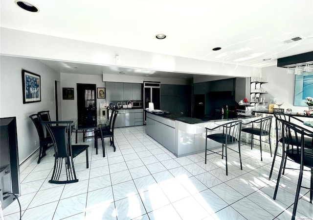 kitchen with a breakfast bar area and light tile patterned floors