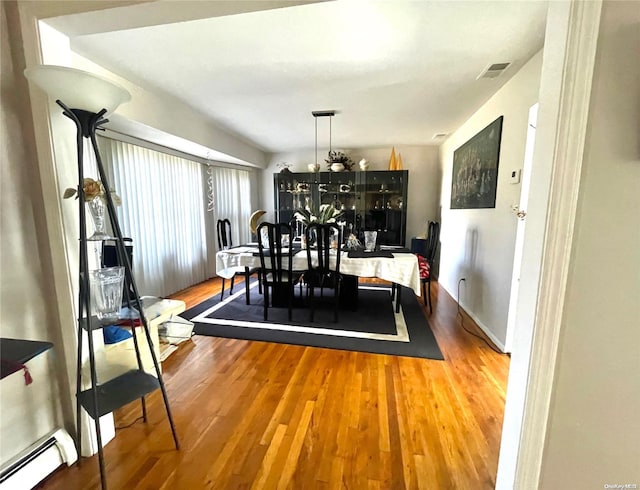 dining room with baseboard heating and wood-type flooring