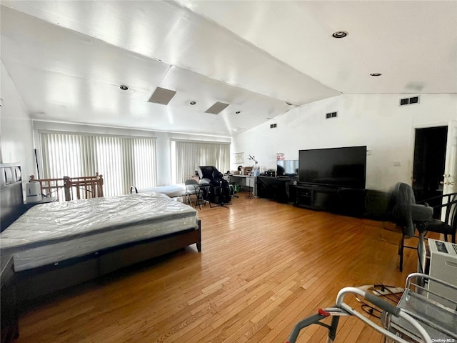 bedroom with wood-type flooring and vaulted ceiling