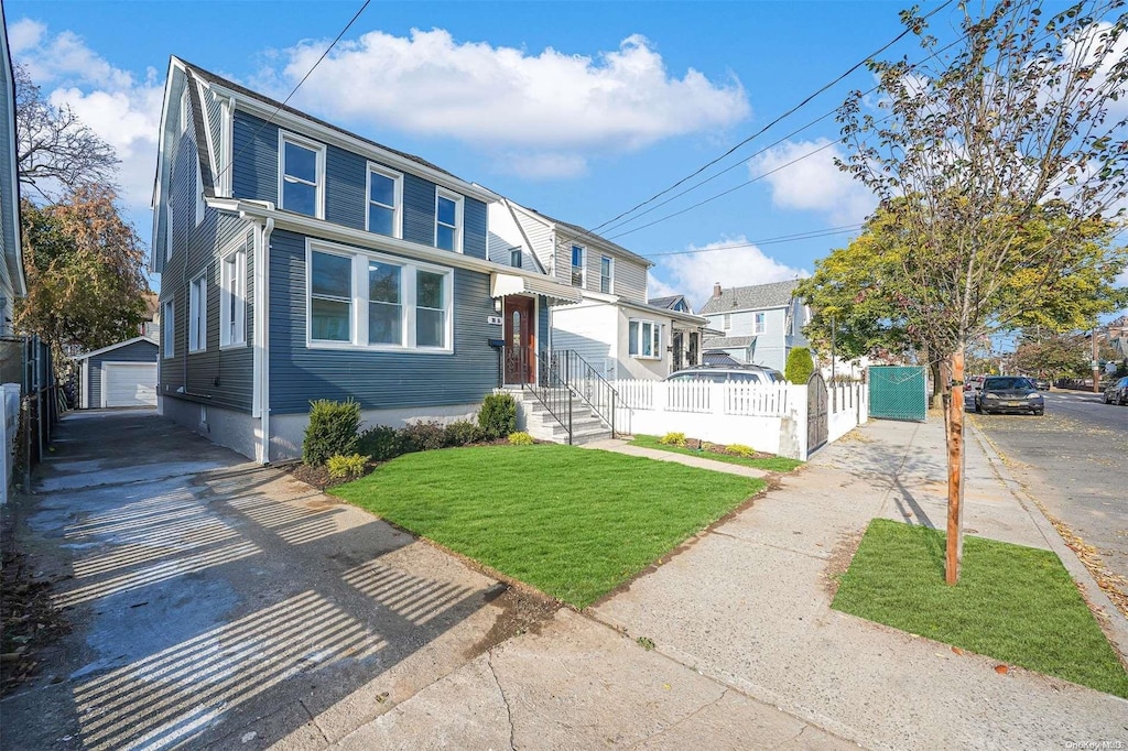 view of front of house with an outbuilding, a front yard, and a garage