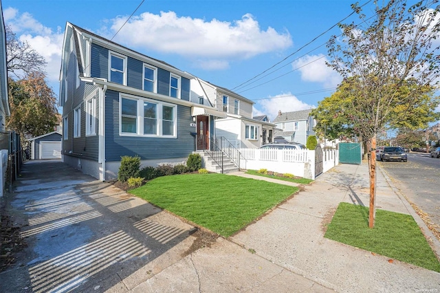 view of front of house with an outbuilding, a front yard, and a garage