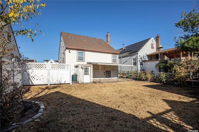 back of house with a patio area and a lawn