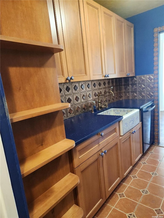 kitchen with dishwasher, dark tile patterned floors, sink, and tasteful backsplash