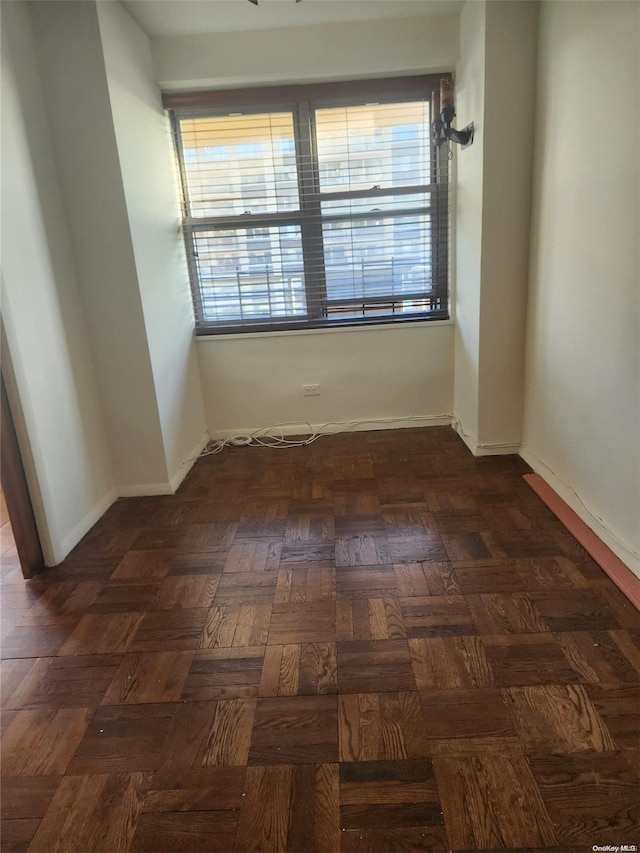 spare room featuring dark parquet floors