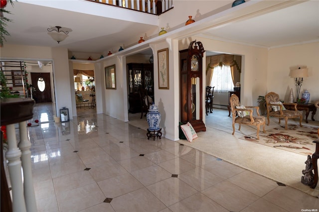 foyer with light colored carpet and ornamental molding