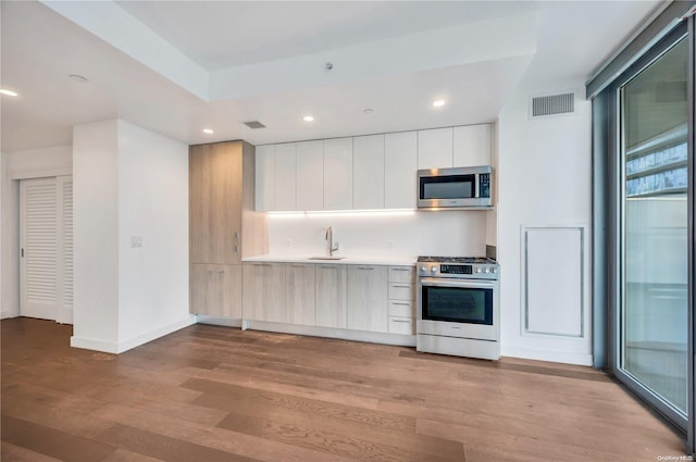 kitchen featuring white cabinets, light hardwood / wood-style floors, sink, and appliances with stainless steel finishes