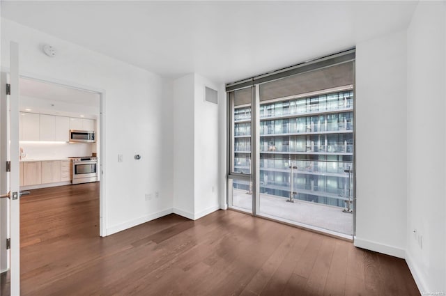 empty room with dark hardwood / wood-style floors and floor to ceiling windows