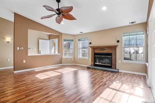 unfurnished living room with hardwood / wood-style flooring, vaulted ceiling, and ceiling fan