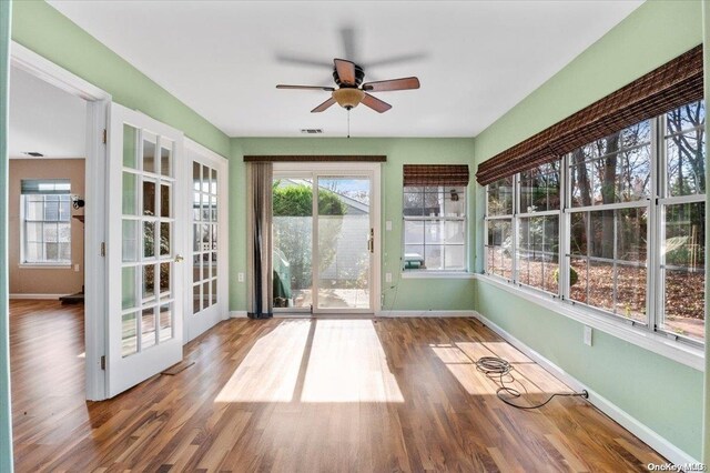 unfurnished sunroom featuring french doors and ceiling fan