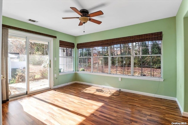 unfurnished sunroom with ceiling fan