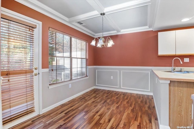 unfurnished dining area with a chandelier, dark hardwood / wood-style floors, ornamental molding, and sink