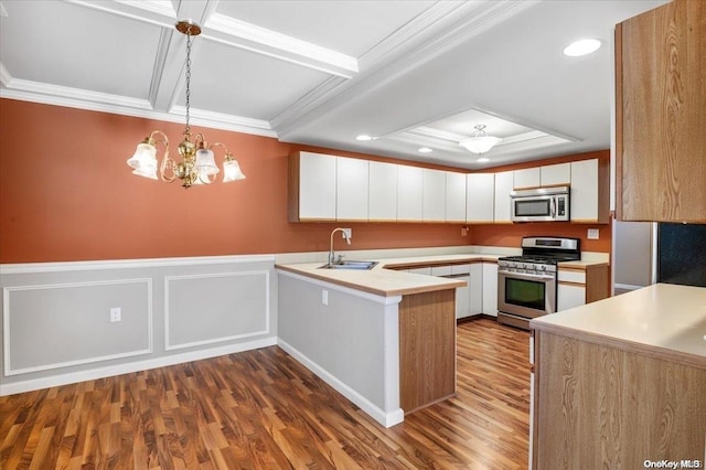 kitchen featuring sink, hanging light fixtures, white cabinetry, kitchen peninsula, and stainless steel appliances