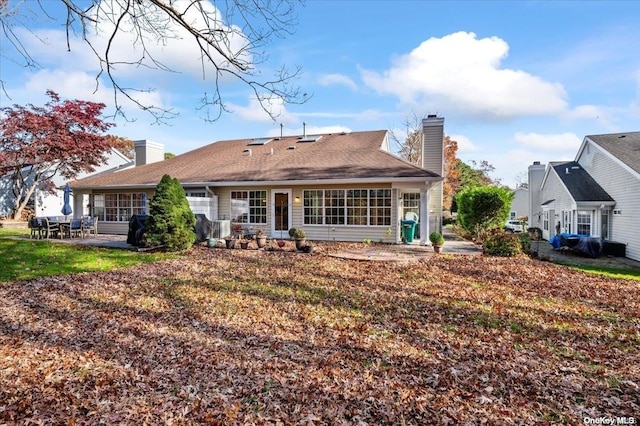 rear view of house featuring a lawn and a patio area