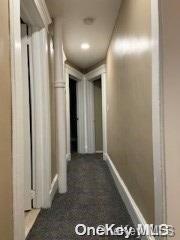 corridor with dark colored carpet