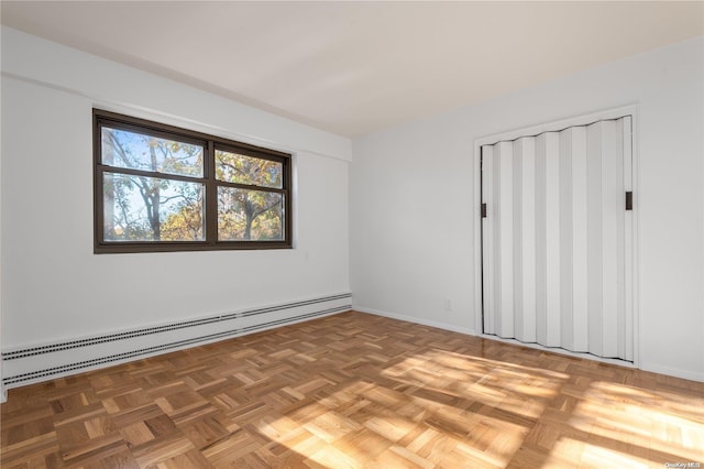 unfurnished room with a baseboard radiator and parquet floors