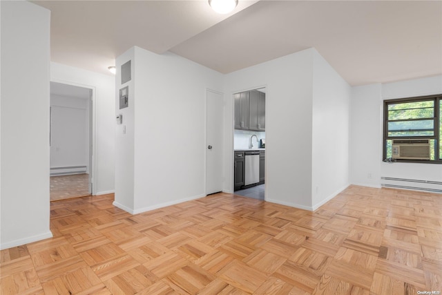 empty room featuring baseboard heating, sink, light parquet floors, and cooling unit