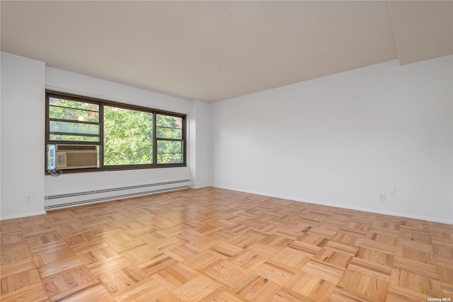 spare room featuring cooling unit, baseboard heating, and light parquet flooring