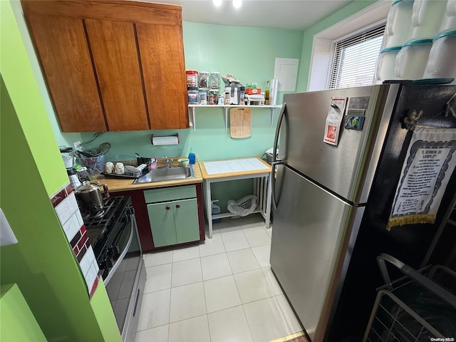 kitchen with stainless steel refrigerator, sink, and light tile patterned flooring