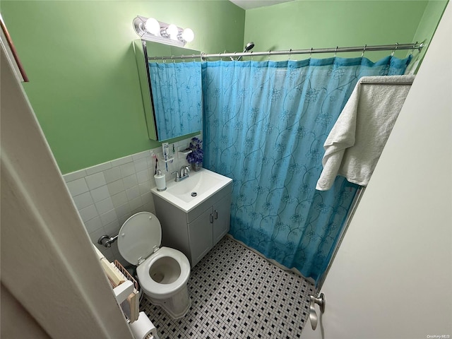 bathroom with vanity, toilet, tile walls, and curtained shower