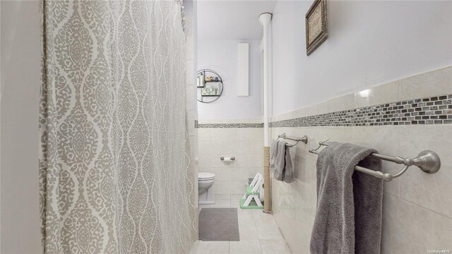 84-51 Beverly Rd Unit 4P, Kew Gardens, NY 11415 - bathroom with tile walls, toilet, tile patterned floors, wainscoting, and a shower with shower curtain
