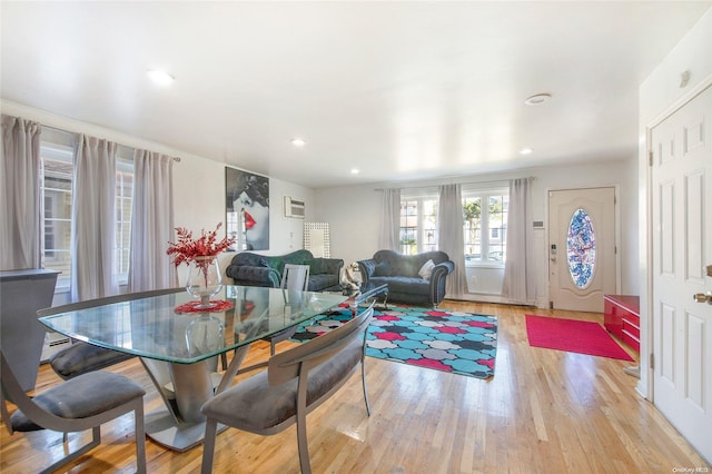 dining space featuring a wall unit AC and light hardwood / wood-style flooring