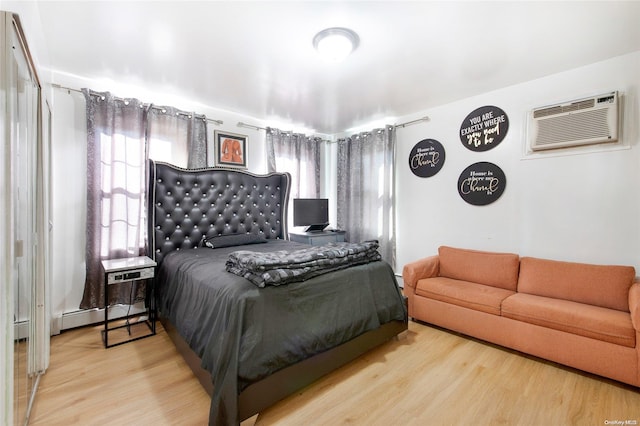 bedroom featuring a wall mounted AC and hardwood / wood-style flooring