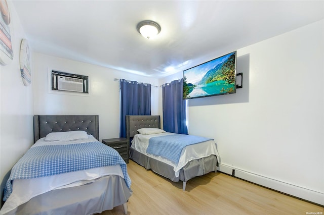 bedroom with light hardwood / wood-style floors, a wall mounted AC, and a baseboard radiator