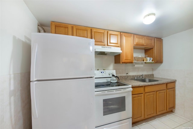 kitchen featuring tile walls, sink, light tile patterned floors, and white appliances