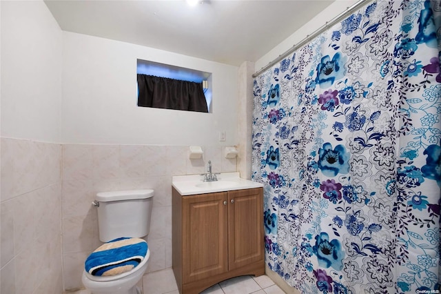 bathroom featuring tile patterned flooring, vanity, toilet, and tile walls