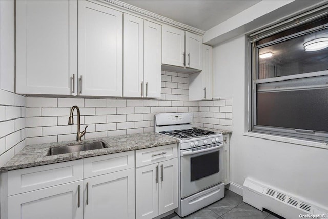 kitchen featuring white gas range, sink, white cabinetry, and baseboard heating