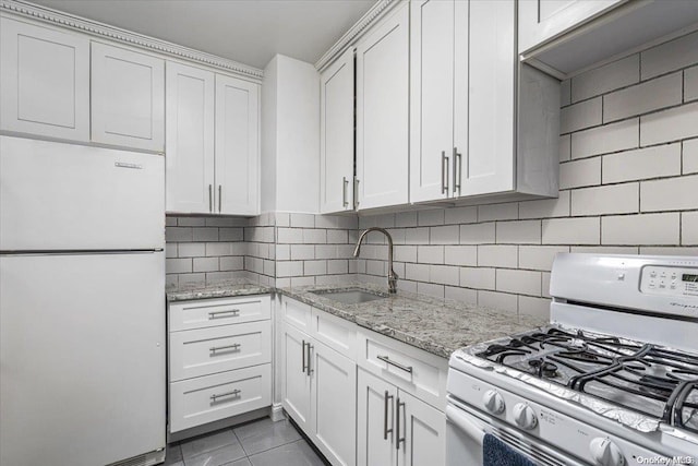 kitchen with decorative backsplash, sink, white cabinets, and white appliances