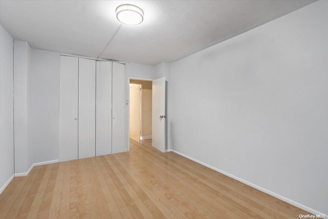 unfurnished bedroom featuring light hardwood / wood-style floors and a closet