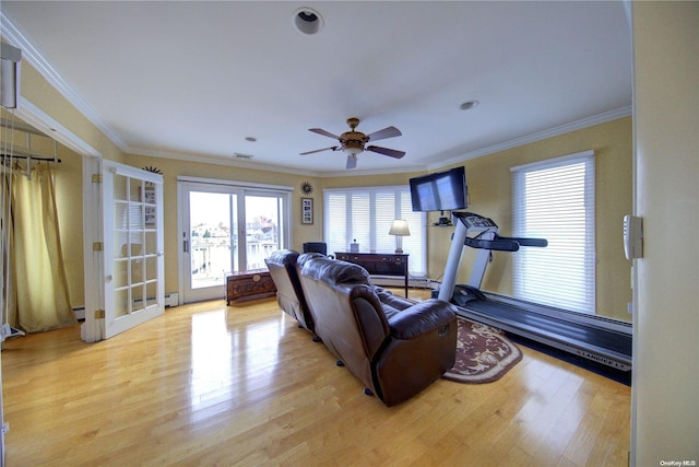 living room with ceiling fan, light wood-type flooring, ornamental molding, and a baseboard heating unit