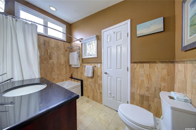 bathroom with vanity, tile patterned floors, toilet, tile walls, and curtained shower