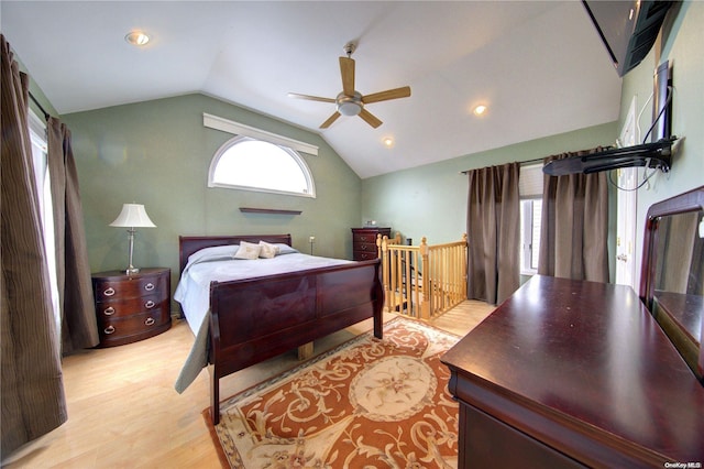 bedroom featuring ceiling fan, light hardwood / wood-style flooring, and lofted ceiling