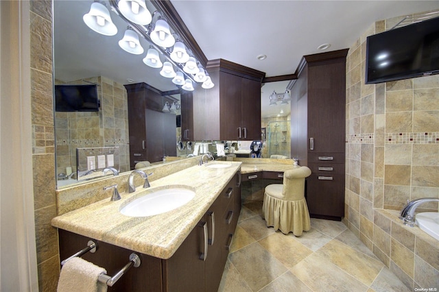 bathroom featuring a bathing tub, tile patterned flooring, vanity, tile walls, and ornamental molding