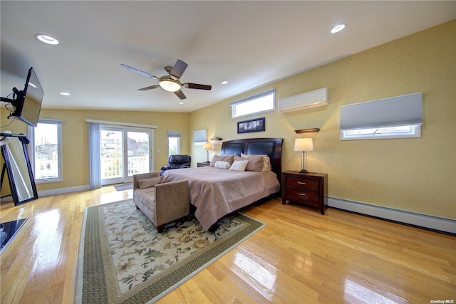 bedroom featuring ceiling fan, light wood-type flooring, a wall unit AC, and baseboard heating