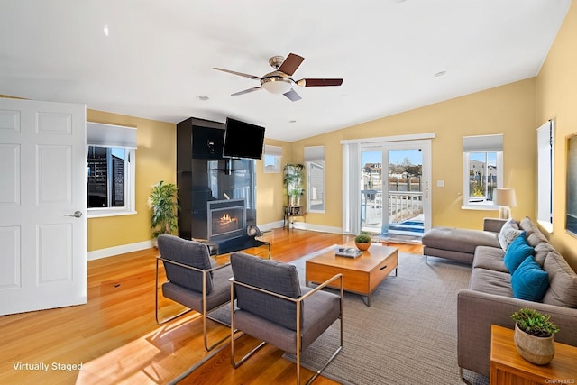 living room featuring a fireplace, hardwood / wood-style flooring, vaulted ceiling, and ceiling fan