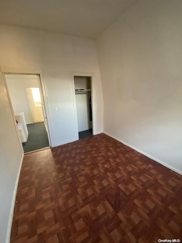 unfurnished bedroom with dark parquet floors