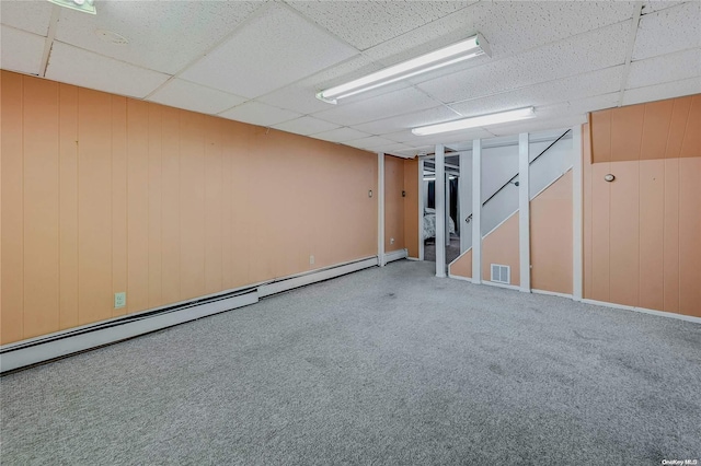 basement featuring carpet floors, baseboard heating, and a drop ceiling