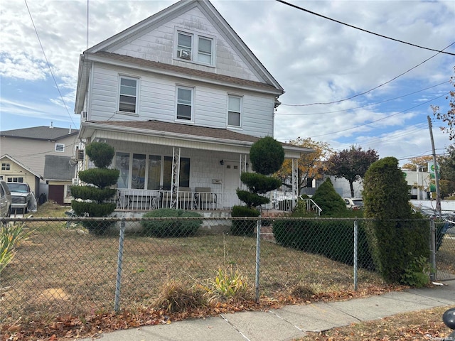 view of front property featuring covered porch and a front yard