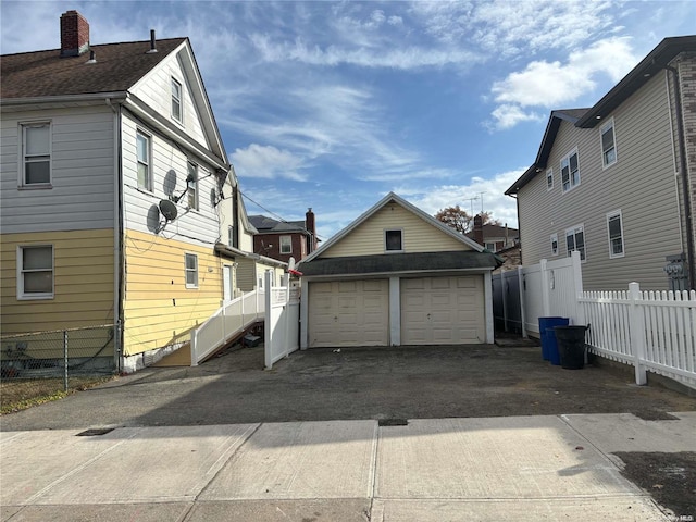 view of property exterior featuring a garage and an outbuilding