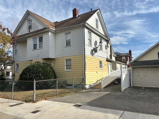 view of side of home featuring an outbuilding and a garage