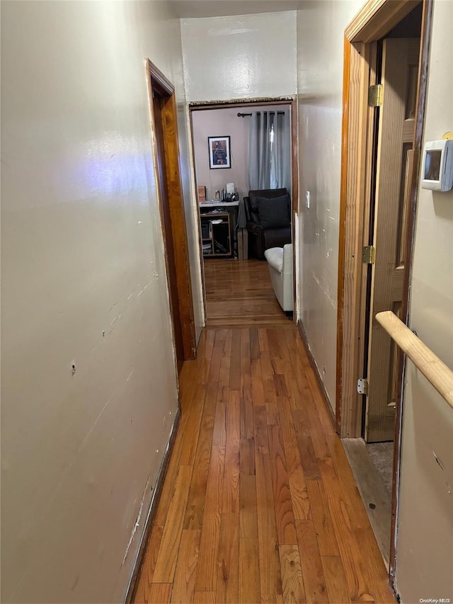 hallway with hardwood / wood-style flooring