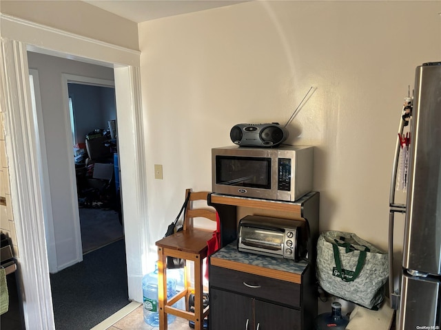 interior space featuring dark brown cabinets, light colored carpet, and appliances with stainless steel finishes