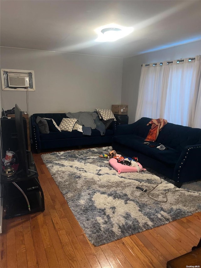 living room featuring a wall mounted air conditioner and hardwood / wood-style floors