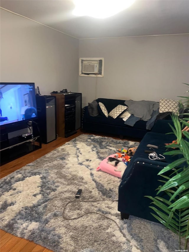 living room with a wall unit AC and dark hardwood / wood-style flooring