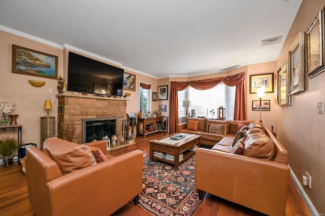 living area featuring crown molding, visible vents, wood finished floors, and a stone fireplace